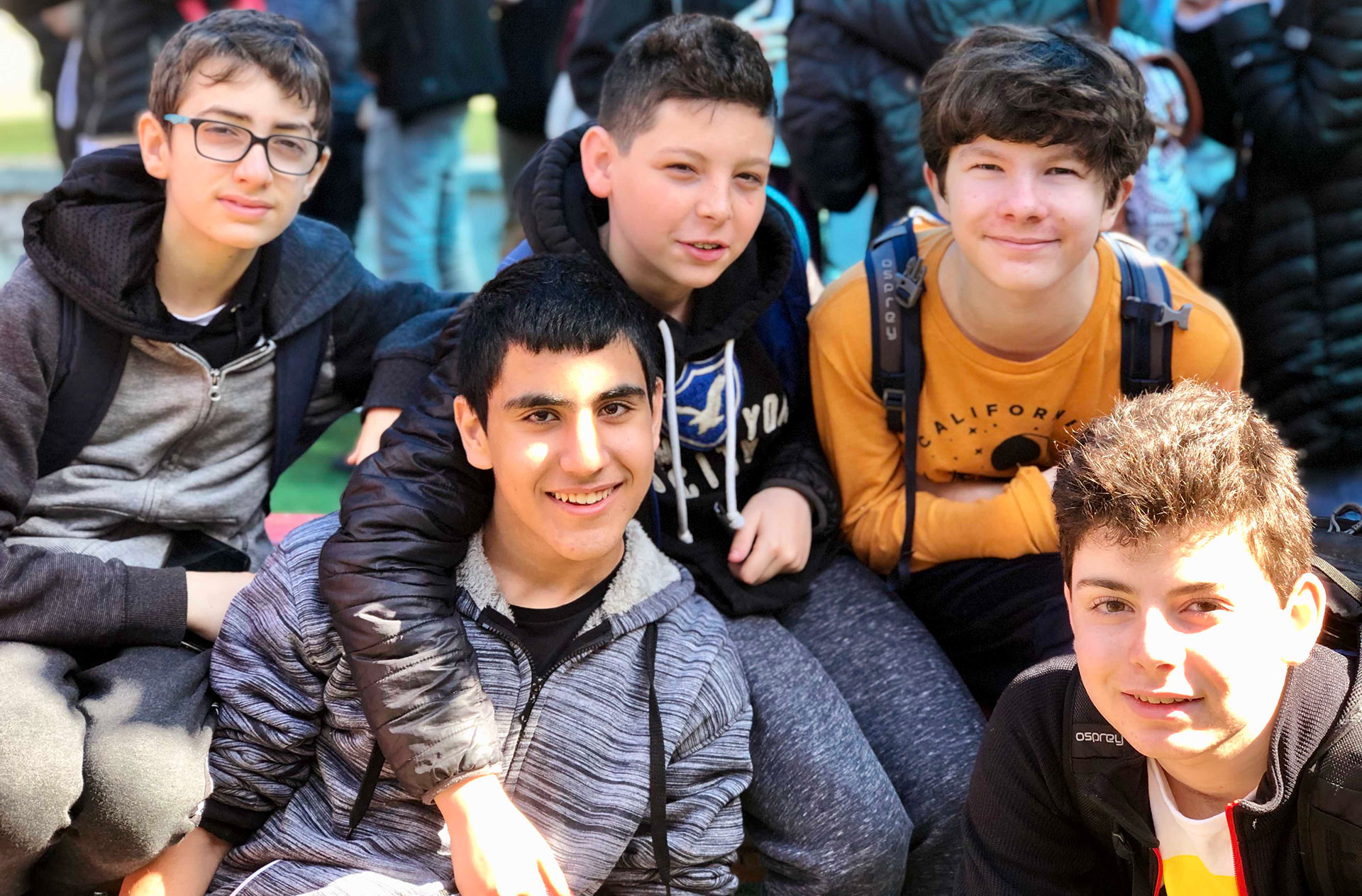 A group of Israeli and American boys sit together outdoors.