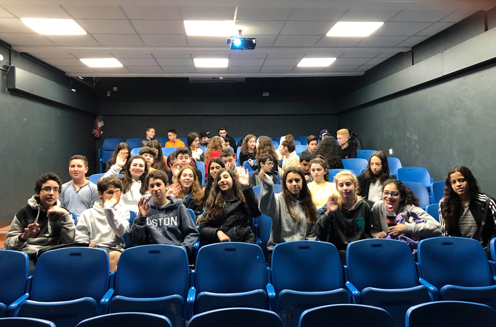 Students from The Rashi School and Leo Baeck pose for a photo while seated in an auditorium in Haifa.