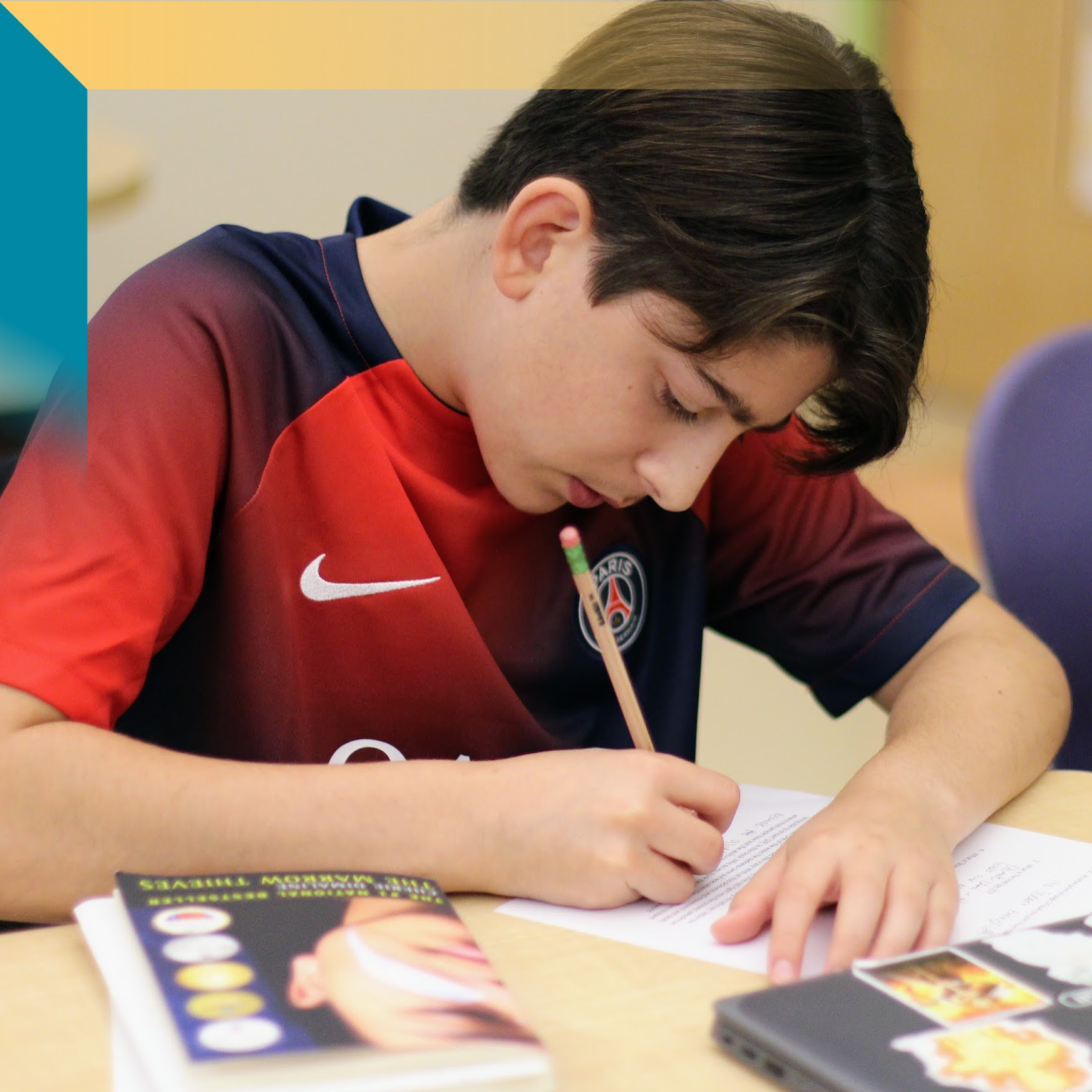 open house 2024 A middle school aged boy leaning over his schoolwork
