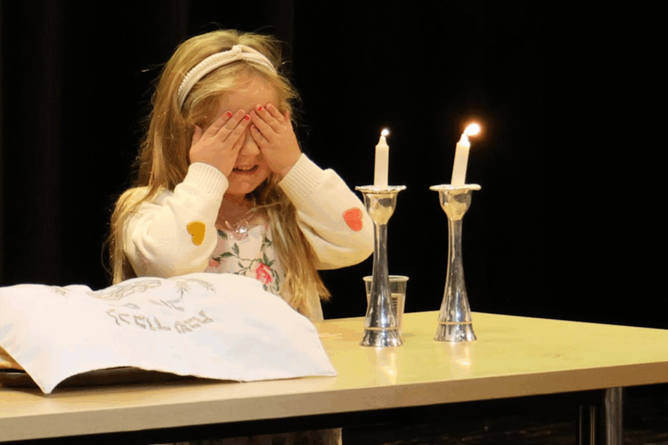 A girl holding a yellow snake around her neck