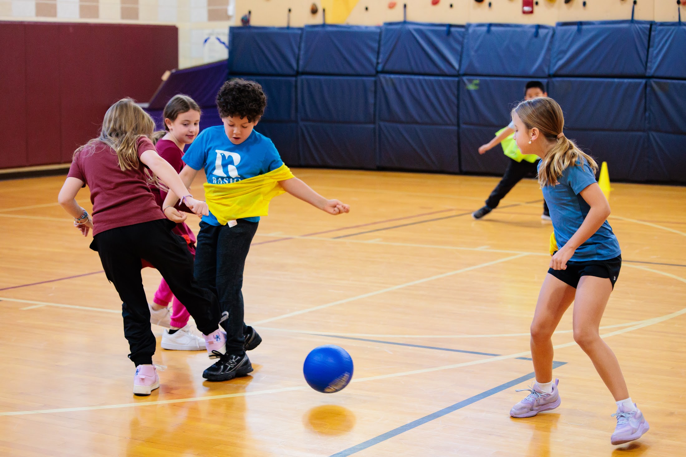 A kindergarten student plays kickball during fitness and health class